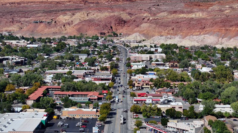 View north along Main Street (U.S. Highway 191) in Moab, Utah, with the downtown below the red rock cliffs and