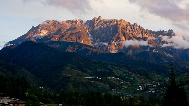 Sunrise illuminating the rocky peaks of Mt. Kinabalu (Sabah, Malaysia), as observed from the town of Kundasang