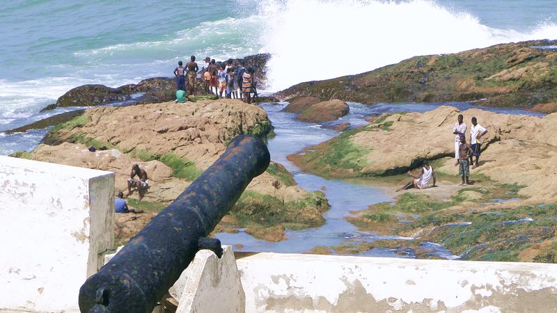 Original caption: "Locals on Seashore below Battlements - Cape Coast Castle - Cape Coast - Ghana"