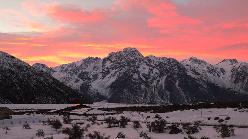 Red morning sky over Burnett Mountains in winter with snow in the Tasman Valley