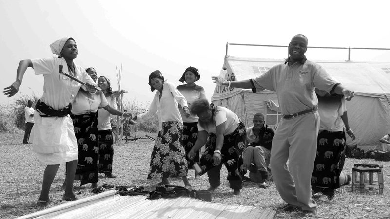 A U.S. Embassy Lusaka in Zambia staffer dances at a program for HIV/AIDS education held for nomadic fisher-fam